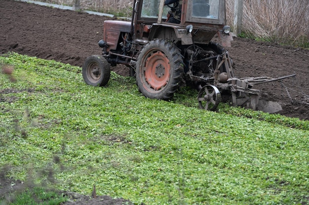 Velho trator da Bielorrússia em um terreno.