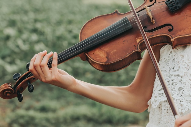 Velho violino nas ternas mãos femininas de uma violinista