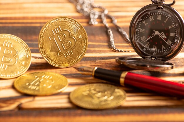 Foto vello reloj y moneda de bit viejo y hermoso reloj y bitcoins en madera rústica y fondo oscuro enfoque selectivo