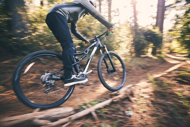 Velocidad de ciclismo y hombre en bicicleta en un camino forestal de tierra haciendo entrenamiento y ejercicio en bicicleta Sendero rápido al aire libre y atleta con bicicleta y energía en una aventura natural con fitness en un camino
