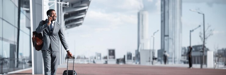 Foto ven al aeropuerto hombre afroamericano caminando con equipaje y hablando por teléfono panorama con copia