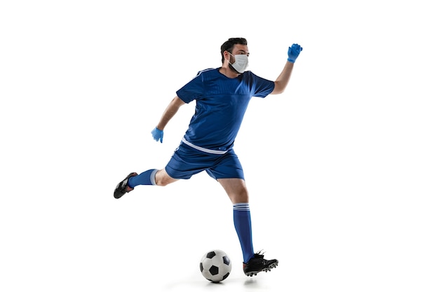 Vença a doença. Futebol masculino, jogador de futebol com máscara protetora. Ainda ativo durante a quarentena. Cuidados de saúde, medicina, conceito de esporte.