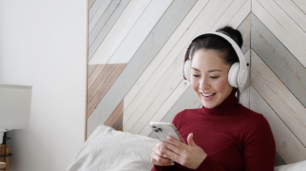 Foto vencedor de menina asiática multiétnica com computador portátil gritando sim e comemorando o sucesso da vitória do jogo online móvel ou obtendo oferta de compras de comércio eletrônico negócios de inicialização e conceito de tecnologia móvel