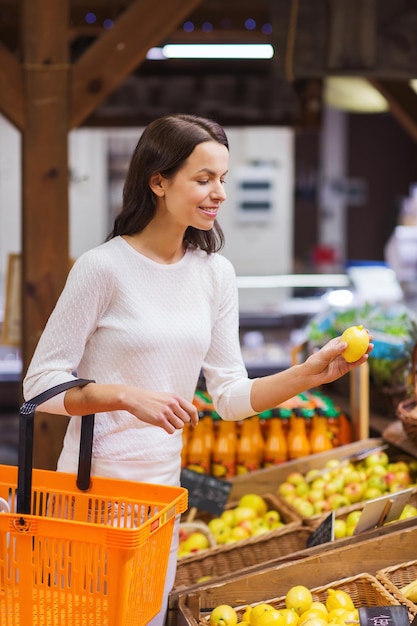 venda, compras, consumismo e conceito de pessoas - jovem feliz com cesta de alimentos no mercado