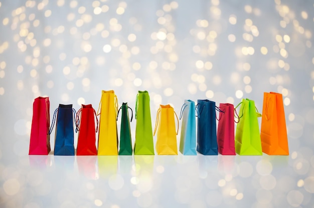 venda, consumismo e conceito de varejo - muitos sacos de compras coloridos sobre fundo de luzes de férias