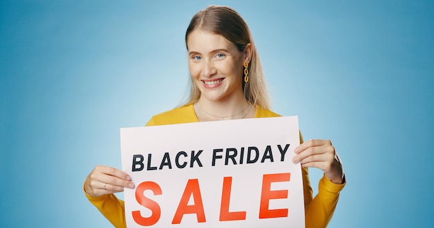 Venda de banners e retrato de mulher em fundo azul para anúncio de notícias e promoção Publicidade de compras e pessoa feliz com cartaz para descontos de sexta-feira negra e bargain no estúdio