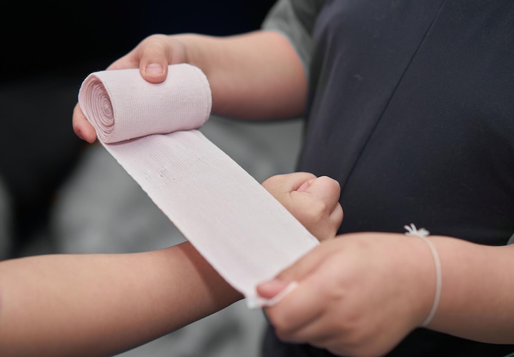 Foto vendaje elástico de gasa enrollado en la mano con adhesivo para primeros auxilios, cuidado de la compresa para la aplicación de accidentes