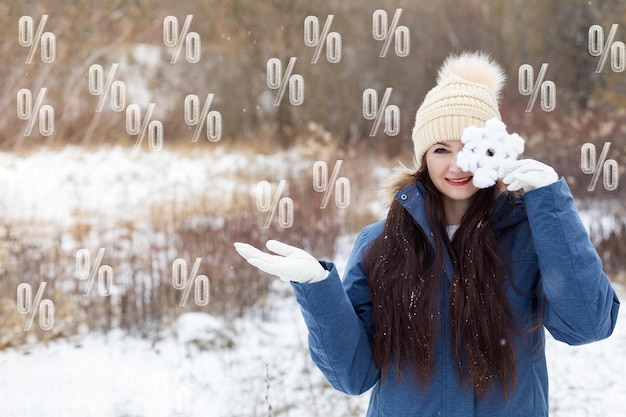 Foto vendas de inverno e conceitos de desconto mulher no fundo da paisagem de inverno e porcentagem voadora