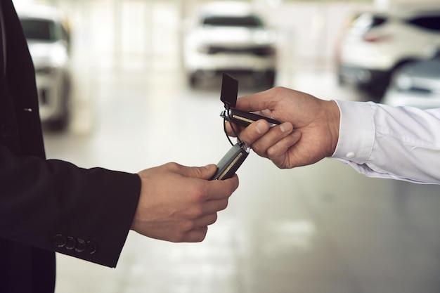 El vendedor de autos entrega las llaves a los clientes que firmaron el contrato de compra