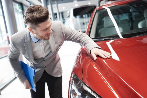 Vendedor de coches examinando el vehículo antes de vender