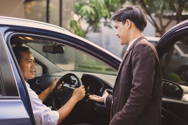 Vendedor de coches que muestra al cliente sobre las características del coche.