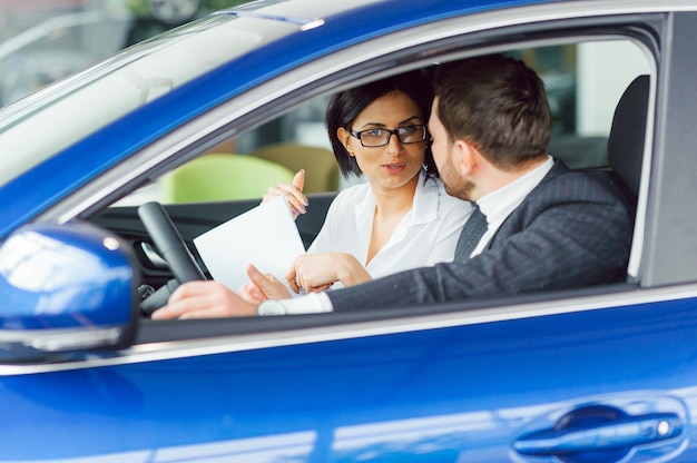 El vendedor y el comprador en el salón del automóvil