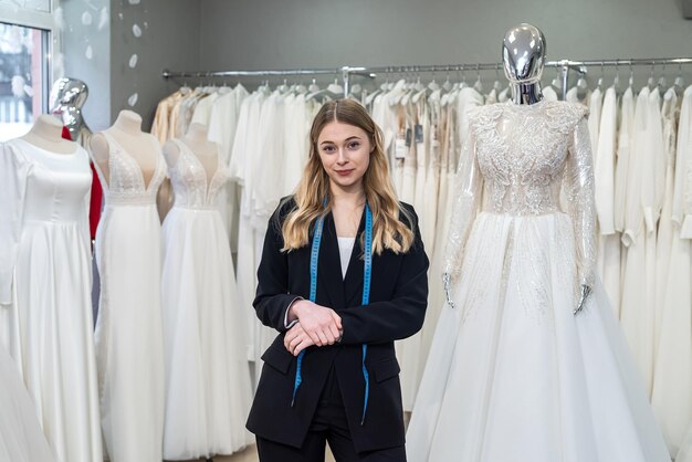 Vendedor de costurera joven posando en el salón de bodas