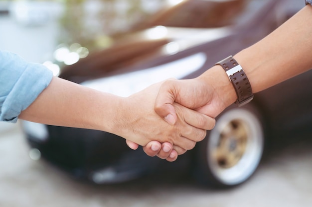 Vendedor, dando a chave ao cliente enquanto cumprimenta a concessionária de automóveis moderna, closeup. comprando carro novo