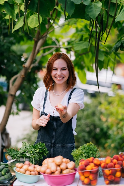 Vendedor de mulher no balcão com legumes Conceito de empresa de pequeno porte