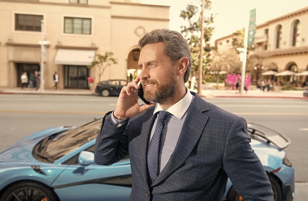 Vendedor de sucesso falando no celular, cara rico, aluga carro