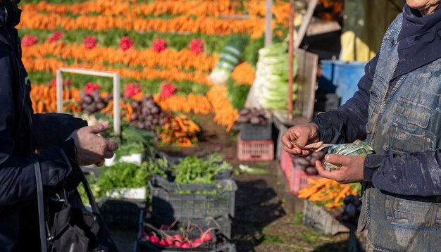 el vendedor devuelve el cambio al cliente en su mercado de verduras