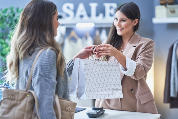 Vendedor e comprador de mulher na loja de roupas. Foto de alta qualidade