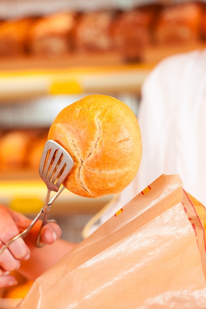 Vendedor está embalando pão na padaria