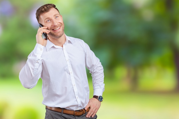 Vendedor guapo hablando por teléfono móvil