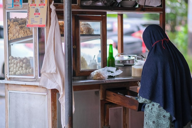 Foto un vendedor local de fideos con albóndigas está preparando un plato de fideos para sus clientes