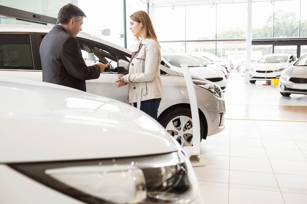 Vendedor, mostrando, um, car, para, um, cliente, em, novo, carro, showroom