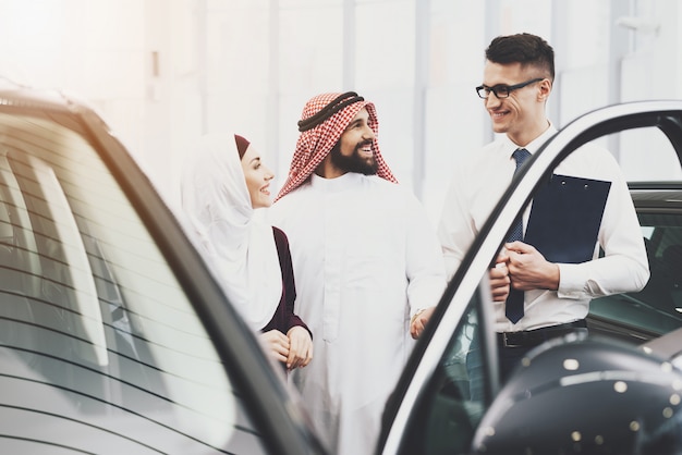 Vendedor oferece crédito automóvel para homem e mulher árabes.