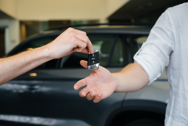 El vendedor pasa las llaves de un auto nuevo a una familia joven