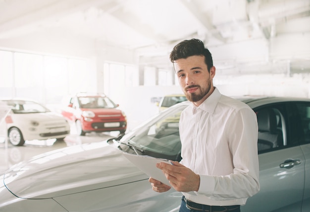 Vendedor presentando autos nuevos en el showroom