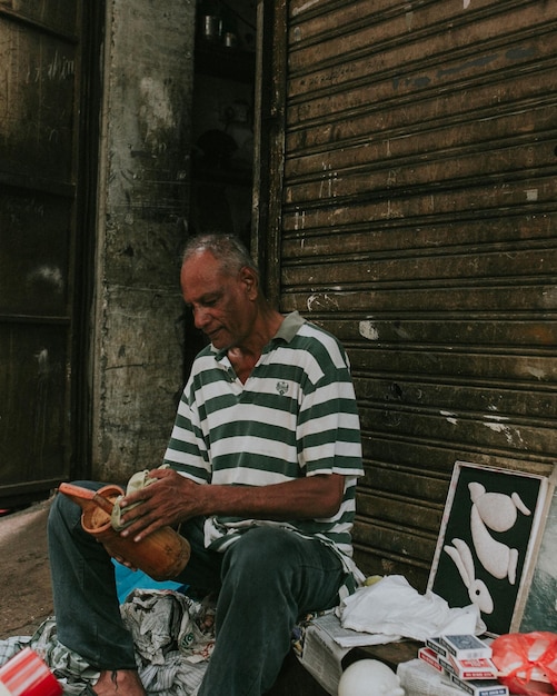 Foto vendedor sentado junto a la persiana