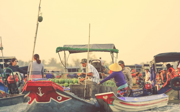 Vendedores vietnamitas comprando sandía en el mercado flotante de Nga Nam