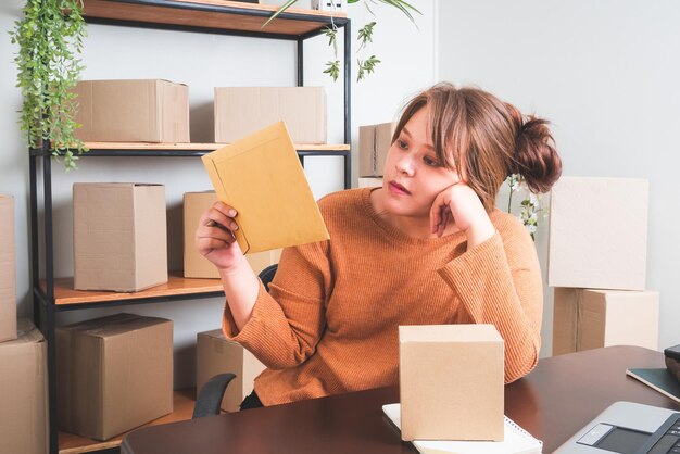 Vender en líneaMujeres de negocios que trabajan en casa y empaquetan en segundo plano Compras en línea de PYME