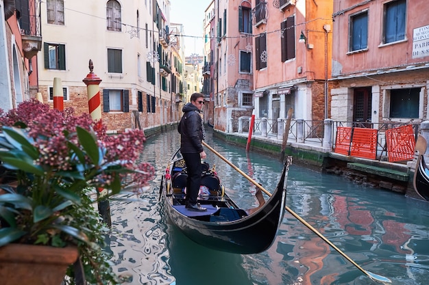 Venecia Italia Gondolero paseos en góndola a través del estrecho canal entre coloridas casas