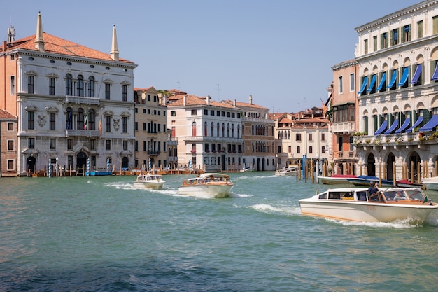 Venedig, Italien - 1. Juli 2018: Panoramablick auf den Canal Grande (Canal Grande) mit aktivem Verkehr Boote. Es ist ein wichtiger Wasserverkehrskorridor in der Stadt Venedig. Landschaft des sonnigen Sommertages und des blauen Himmels