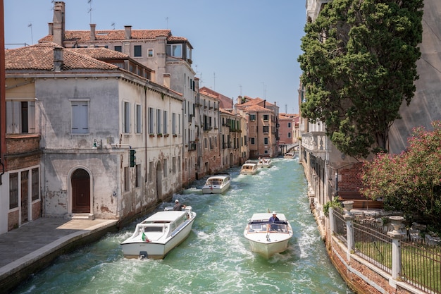 Venedig, Italien - 1. Juli 2018: Panoramablick auf den schmalen Kanal von Venedig mit historischen Gebäuden und Bootsverkehr von der Brücke Foscari. Landschaft des sonnigen Sommertages und des blauen Himmels