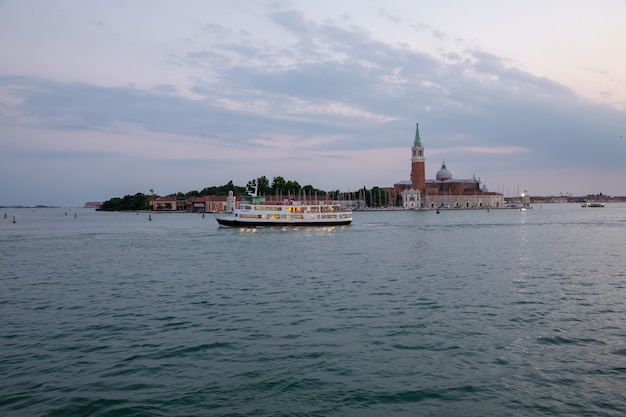 Venedig, Italien - 1. Juli 2018: Panoramablick auf die Laguna Veneta der Stadt Venedig mit Gondeln und der Insel San Giorgio Maggiore. Landschaft des Sommermorgentages und des dramatischen blauen Himmels