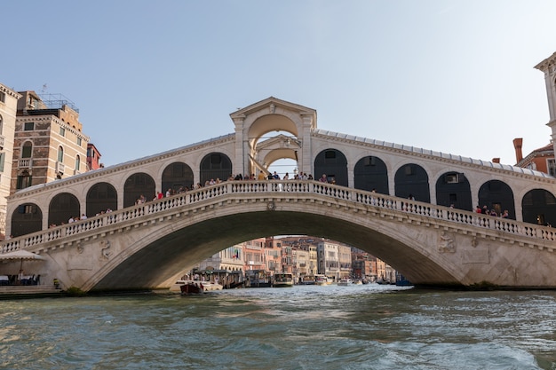 Venedig, Italien - 2. Juli 2018: Panoramablick auf die Rialtobrücke (Ponte di Rialto) ist die älteste der vier Brücken über den Canal Grande in Venedig von der Gondel. Sonniger Sommertag und blauer Himmel