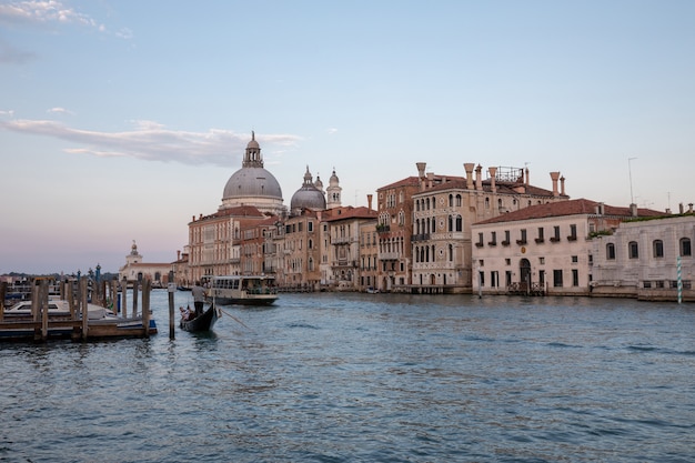 Veneza, Itália - 30 de junho de 2018: Vista panorâmica da vista do grande canal de Veneza com edifícios históricos, gôndola e barcos, longe da Basílica Salute. Paisagem de dia de noite de verão e céu colorido