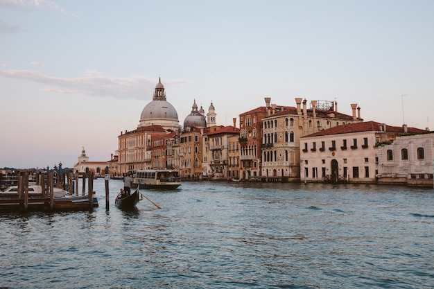 Veneza, Itália - 30 de junho de 2018: Vista panorâmica da vista do grande canal de Veneza com edifícios históricos, gôndola e barcos, longe da Basílica Salute. Paisagem de dia de noite de verão e céu colorido