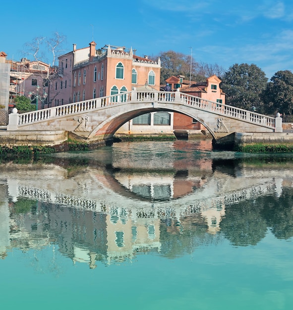 Venezianische Brücke, die sich im Wasser widerspiegelt