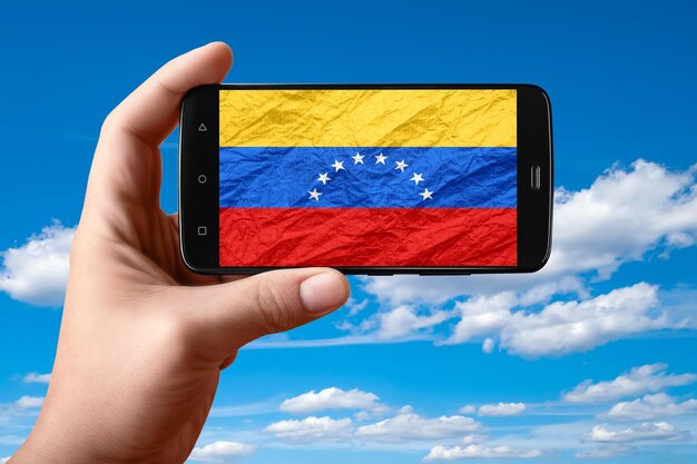 Venezuela-Flagge auf dem Telefonbildschirm Smartphone in der Hand zeigt eine Flagge