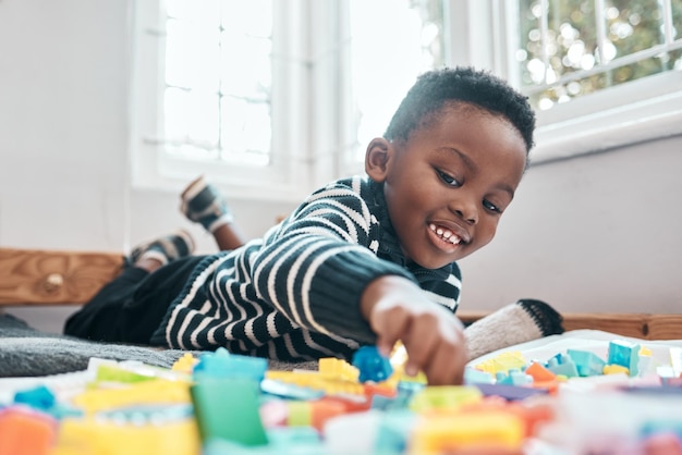 Venha brincar comigo Foto de um garotinho adorável brincando com blocos de construção em casa