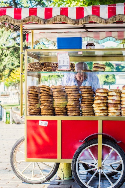 Foto venta de bagel simit turco en la calle en el área de sultan ahmet del carro rojo tradicional, estambul, turquía