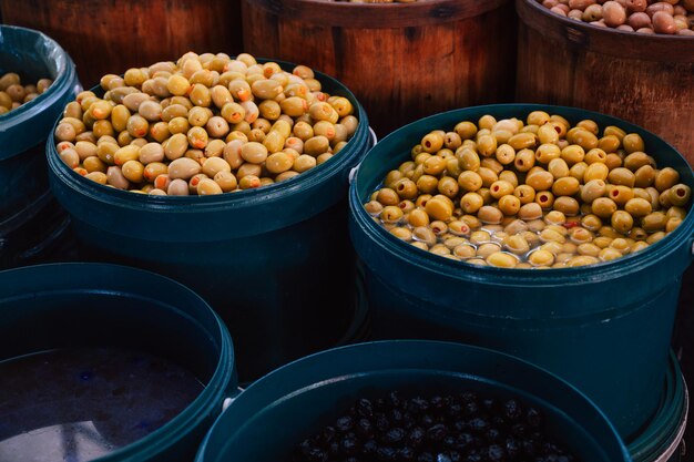 Venta de diferentes aceitunas en el mercado tradicional turco de granja, un mostrador lleno de frutas frescas