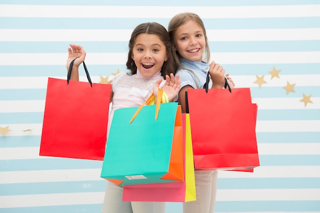 Venta niña feliz compró mucho en gran venta niñas pequeñas en compras con caras felices