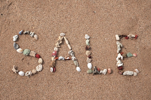 Venta de texto hecha de concha en la playa de arena