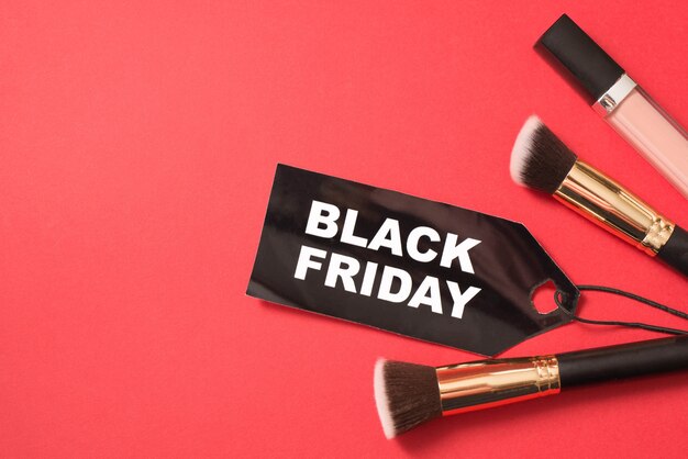 Foto venta de viernes negro de cosméticos sobre fondo rojo con un espacio de copia
