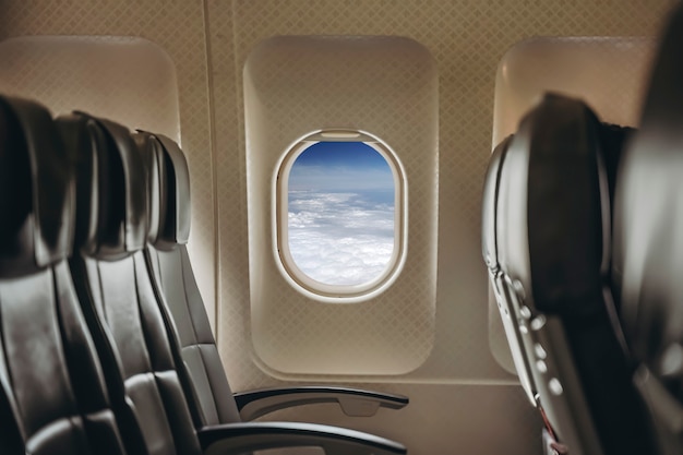 Ventana del aeroplano en el interior claro y soleado de un avión de pasajeros con una ventana abierta en vuelo h ...