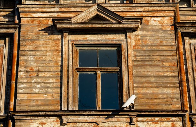 Ventana de una antigua casa de madera con cámara de videovigilancia