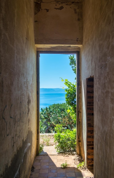 Ventana de un antiguo edificio abandonado con vistas al mar